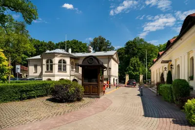 a dining room with tables and chairs and windows at Hotel Maltański in Kraków