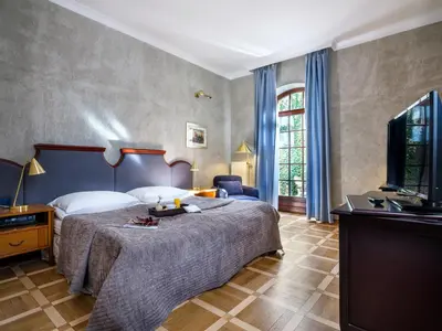 a living room with a staircase and a fireplace at Hotel Maltański in Kraków