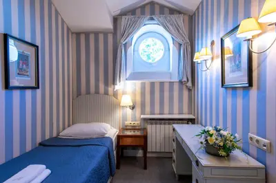 a small bedroom with a bed and a window at Dom Pugetów in Kraków