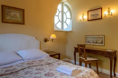 a bedroom with a bed and a desk and a window at Dom Pugetów in Kraków