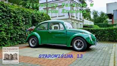a small green car parked in a parking lot at Dom Pugetów in Kraków