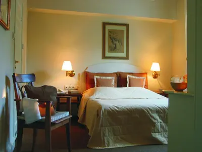 a bedroom with a bed and a desk with a chair at Dom Pugetów in Kraków