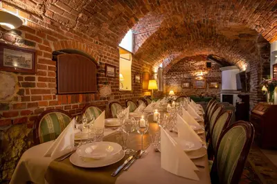 a dining room with a long table and chairs at Dom Pugetów in Kraków