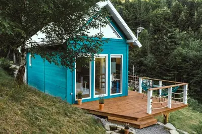a blue tiny house with a wooden deck at RESETówka nr 3 - domek na odludziu z mega widokami - Lazurowe Love in Jaszczurowa