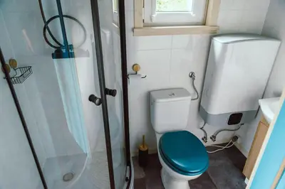 a small bathroom with a toilet and a shower at RESETówka nr 3 - domek na odludziu z mega widokami - Lazurowe Love in Jaszczurowa