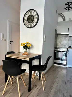 a dining room table with chairs and a clock on the wall at Flow 8 by Housine in Zator