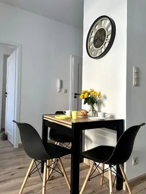 a dining room table with chairs and a clock on the wall at Flow 8 by Housine in Zator