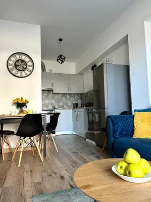 a kitchen and living room with a blue couch and a table at Flow 8 by Housine in Zator