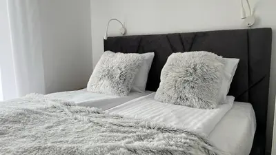 a bed with white pillows and a gray blanket at Chill & Fun 22 by Housine in Zator