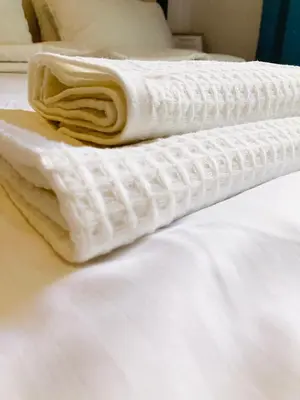 two white towels sitting on top of a bed at Supreme Apartment in the City Center in Kraków