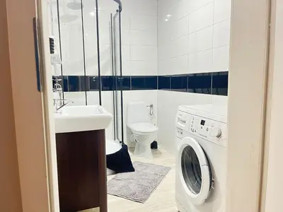 a bathroom with a washing machine and a sink at Apartament Blondynka Miasto Soli Bochnia in Bochnia