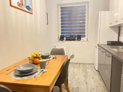 a kitchen with a wooden table and chairs in a kitchen at Apartament Blondynka Miasto Soli Bochnia in Bochnia