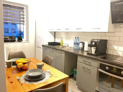 a kitchen with a table with a bowl of fruit on it at Apartament Blondynka Miasto Soli Bochnia in Bochnia