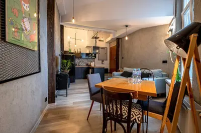 a dining room and living room with a table at Orzeszkowej PREMIUM Apartament in Kraków