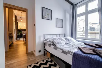 a bedroom with a bed and a large window at Orzeszkowej PREMIUM Apartament in Kraków
