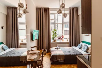 a hotel room with two beds and a table at Apartament na Krakowskim Kazimierzu in Kraków