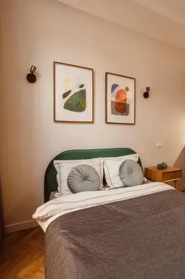 a bedroom with a bed with two pictures on the wall at Apartament na Krakowskim Kazimierzu in Kraków