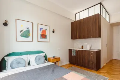 a bedroom with a bed and a small kitchen at Apartament na Krakowskim Kazimierzu in Kraków