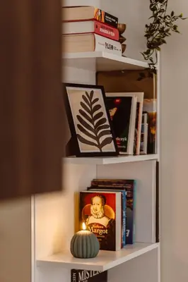 a book shelf with books and a pumpkin on it at Apartament na Krakowskim Kazimierzu in Kraków