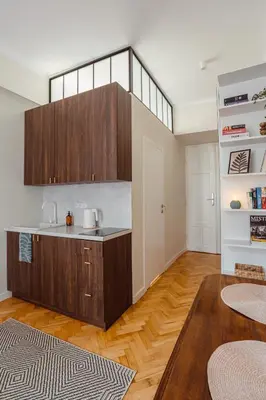 a kitchen with brown cabinets and a wooden floor at Apartament na Krakowskim Kazimierzu in Kraków