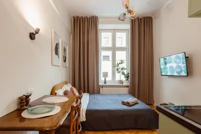 a small bedroom with a bed and a table at Apartament na Krakowskim Kazimierzu in Kraków