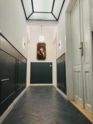 a hallway with black doors and a painting on the wall at Apartament na Krakowskim Kazimierzu in Kraków