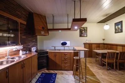 a large kitchen with wooden cabinets and a table at Golden Lion Guest Rooms Szewska 19 in Kraków