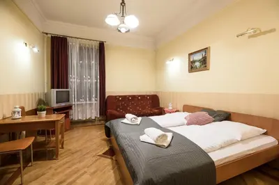 a bedroom with a bed and a table and a couch at Golden Lion Guest Rooms Szewska 19 in Kraków