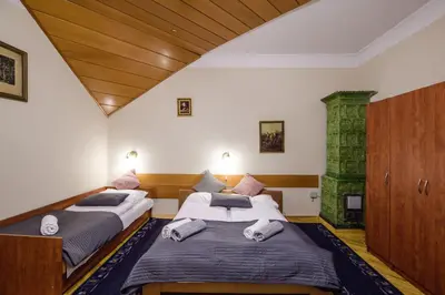 two beds in a room with a fireplace at Golden Lion Guest Rooms Szewska 19 in Kraków
