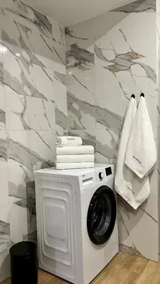 a washing machine in a bathroom with marble walls at Apartament 36 Zator by Housine in Zator