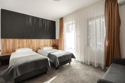 a bedroom with two beds and a window at Hotel Solny in Wieliczka