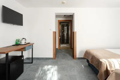 a hotel room with a bed and a desk and a television at Hotel Solny in Wieliczka