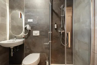 a bathroom with a shower and a toilet and a sink at Hotel Solny in Wieliczka