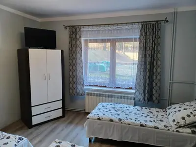 a bedroom with two beds and a dresser and a window at Agroturystyka Leśna Ostoja Borek in Golczowice