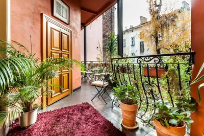 a balcony with potted plants and a door at Aparthotel Oberża in Kraków