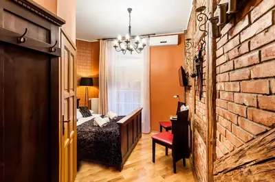 a bedroom with a bed and a brick wall at Aparthotel Oberża in Kraków