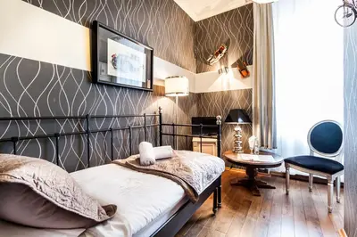 a bedroom with a bed and a table and a chair at Aparthotel Oberża in Kraków