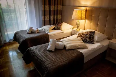 a hotel room with two beds and a lamp at Aparthotel Oberża in Kraków