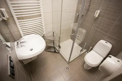 a bathroom with a sink and a toilet and a shower at Aparthotel Oberża in Kraków