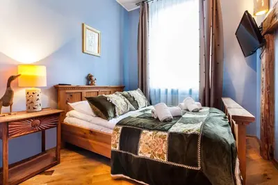 a bedroom with a bed and a window at Aparthotel Oberża in Kraków