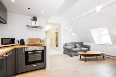 a kitchen and living room with a couch and a table at Urban Nest Apartments Bon 11 in Kraków