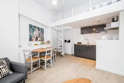 a kitchen and living room with a table and a couch at Urban Nest Apartments Bon 11 in Kraków