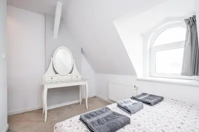 a white bedroom with a mirror and a bed at Urban Nest Apartments Bon 11 in Kraków