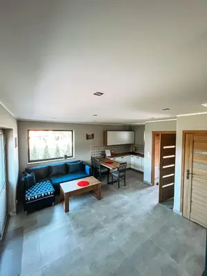 a living room with a blue couch and a table at Nova 26 in Klucze