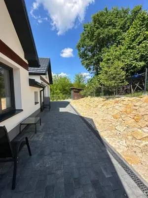 a brick walkway next to a building with a tree at Nova 26 in Klucze