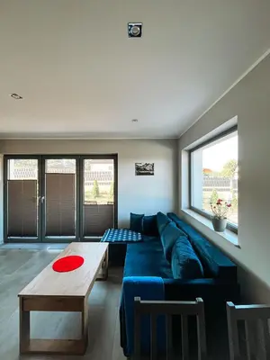 a living room with a blue couch and a table at Nova 26 in Klucze