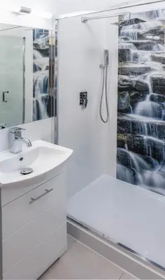 a white bathroom with a shower and a sink at Old Cracow Apartment in Kraków