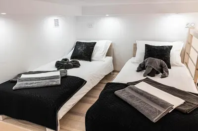 two beds in a room with black and white at Old Cracow Apartment in Kraków