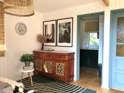 a living room with a wooden cabinet and a kitchen at Domek Pod Lasem in Trzciana