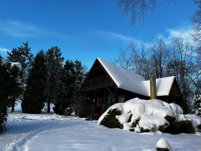 a cabin covered in snow with a pile of snow at Domek Pod Lasem in Trzciana
